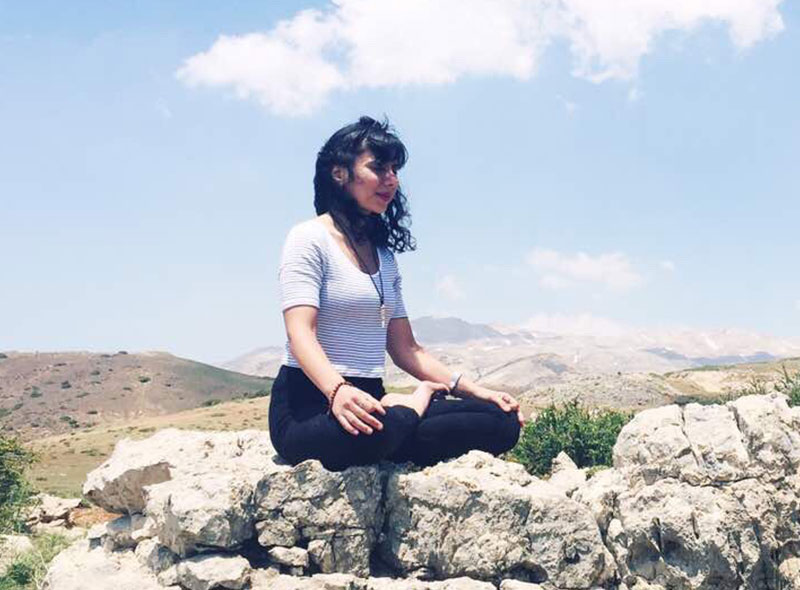 Sandy Boutros meditating on the rocks