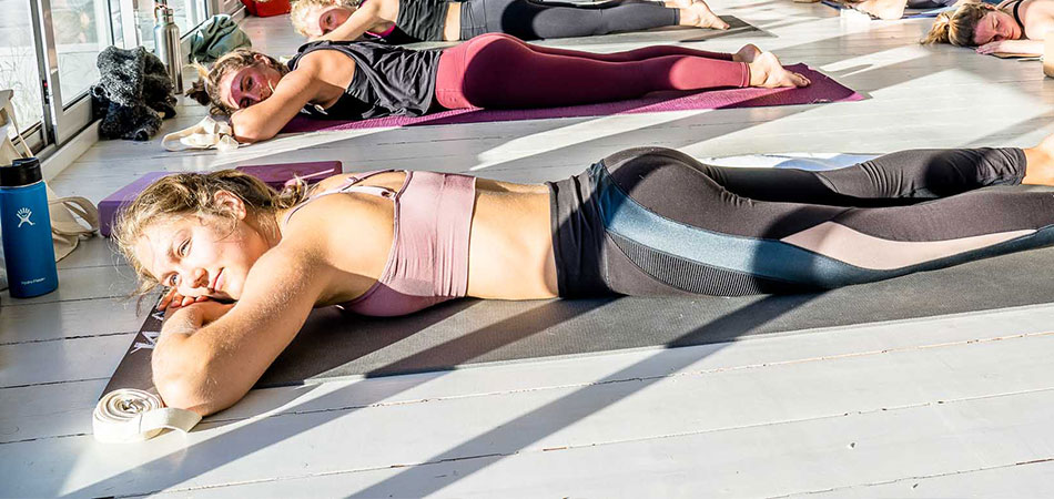 Students resting on their mat during yoga class