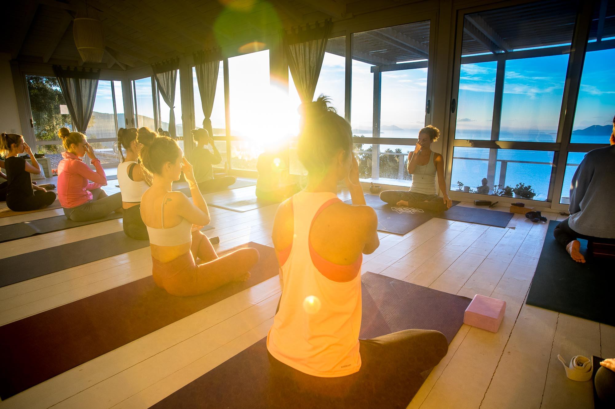 a yoga teacher and her students meditating