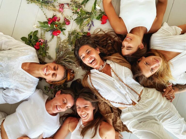 Yoga students smiling on the ground after graduating from one of the best yoga teacher training in Europe.